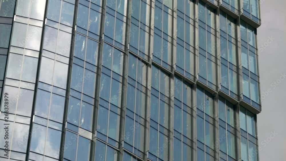 Time lapse of clouds reflecting onto the glass of a large office building. Modern Business Office Buildings with Glass Reflection. Reflection of clouds in a modern skyscraper. Time lapse of clouds reflecting onto the glass of a large office building. Modern Business Office Buildings with Glass Reflection. Reflection of clouds in a modern skyscraper.
