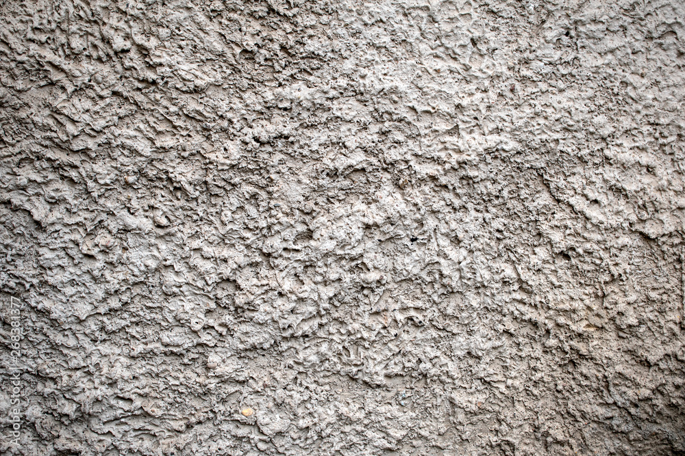 The texture of the gray stony surface covered with cement