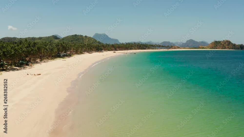 Aerial drone tropical sandy beach and blue water. Nacpan, El Nido, Palawan, Philippines. Seascape with sea, sand, palm trees. Summer and travel vacation concept Aerial drone tropical sandy beach and blue water. Nacpan, El Nido, Palawan, Philippines. Seascape with sea, sand, palm trees. Summer and travel vacation concept