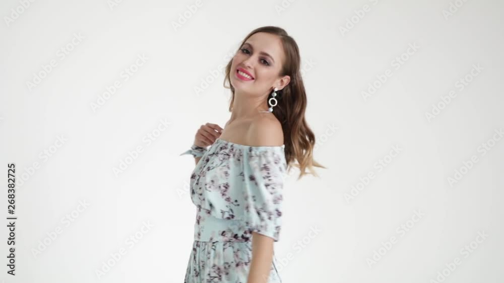 Cute girl in a dress with a flower coloring, smiling on a white background. The style of 60-ies. Fashionable clothes in the style of 60-ies Cute girl in a dress with a flower coloring, smiling on a white background. The style of 60-ies. Fashionable clothes in the style of 60-ies
