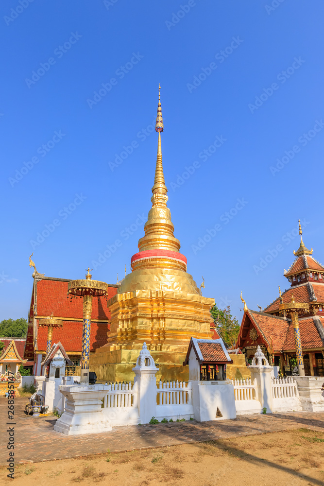 Fototapeta premium Golden pagoda and Buddha pavilion at Wat Pong Sanuk temple and museum in Lampang, North of Thailand