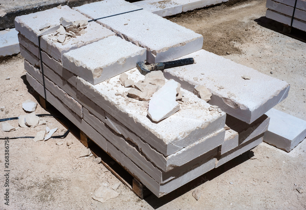 Closeup of a large piece of marble and a hammer after splitting marble for further work.