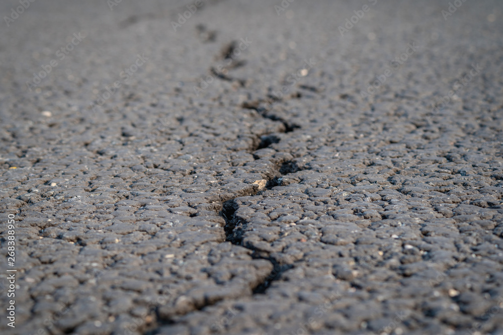 terrible crack in the road pavement, close up blurry background terrible crack in the road pavement, close up blurry background
