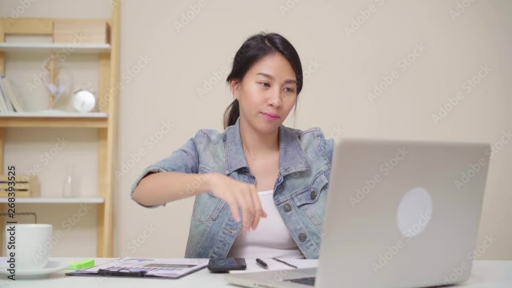 Young asian woman working using laptop on desk in living room at home. Asia business woman success celebration feeling happy dancing at home office. Enjoying time at home concept. Young asian woman working using laptop on desk in living room at home. Asia business woman success celebration feeling happy dancing at home office. Enjoying time at home concept.