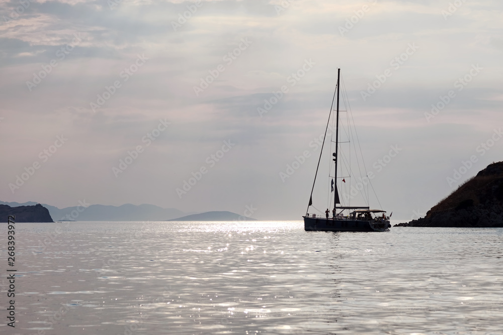 Sailboat anchored over the calm sea at dawn