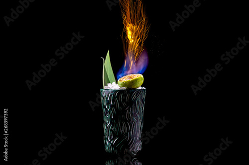 zombie cocktail with fire on a black background with reflection