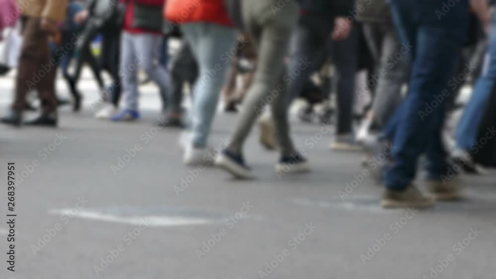Side view blurry pedestrians walking. Detail of legs crossing a street in the city of Barcelona. Side view blurry pedestrians walking. Detail of legs crossing a street in the city of Barcelona.