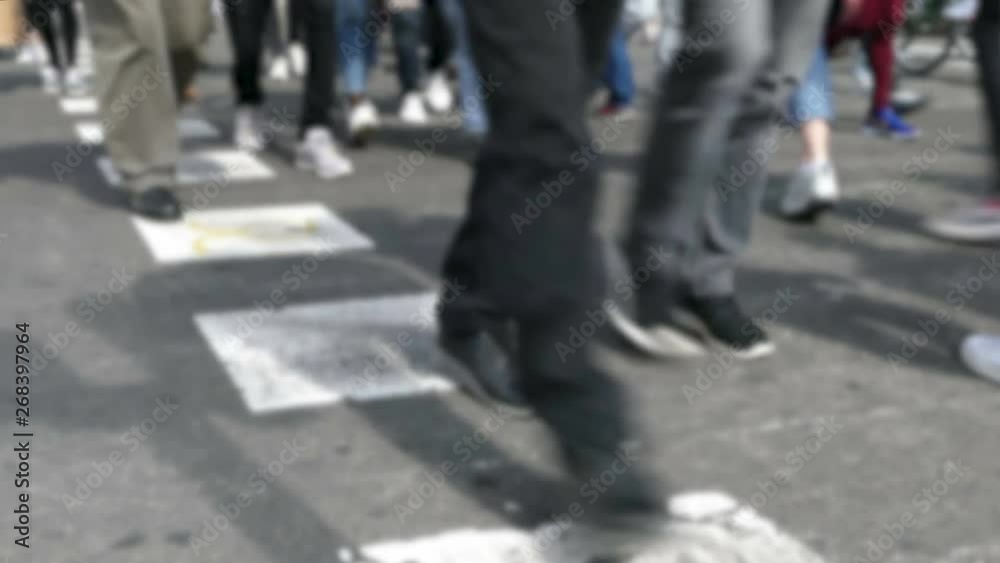 Front view blurry pedestrians walking. Detail of legs crossing a street in the city of Barcelona. Front view blurry pedestrians walking. Detail of legs crossing a street in the city of Barcelona.