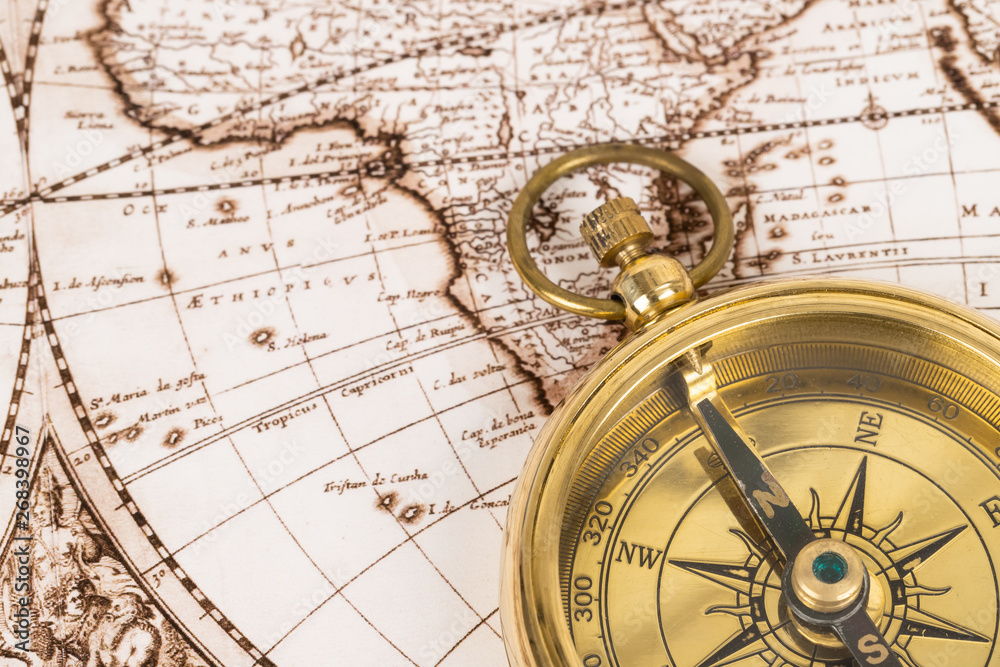 Compass on vintage ancient map, concept for direction transportation and travel
