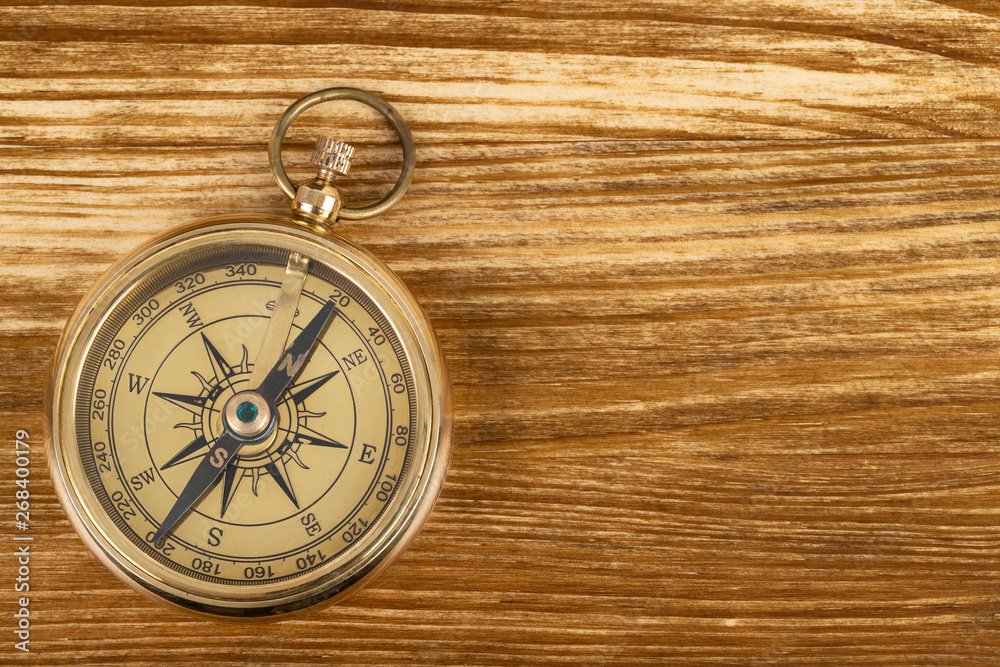 Compass on wooden background, concept for direction transportation and travel, with copy space
