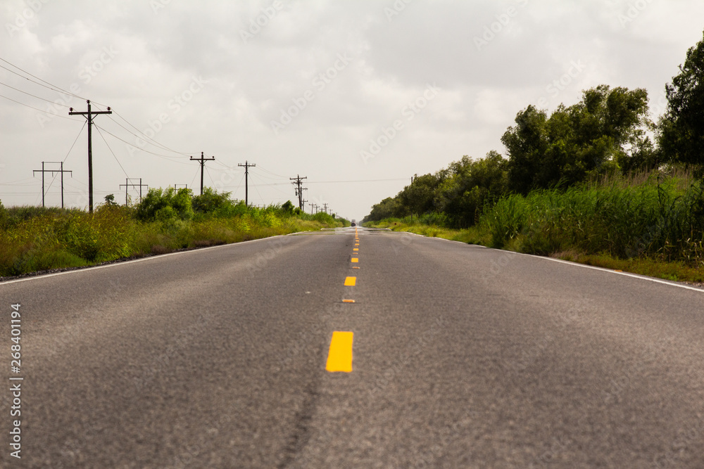 Road lines in empty road with clouds