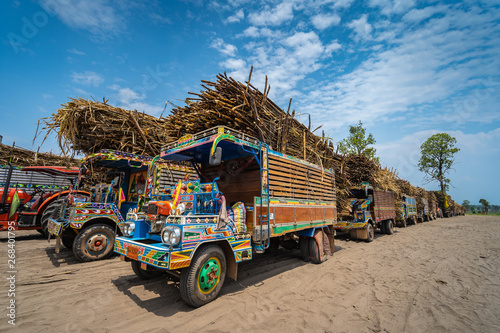 UDON THANI, THAILAND - APRIL 3, 2019 : Traditional Thai farming trucks transporting sugar cane to the factory..Etan Thai Farm Trucks are ubiquitous on Isaan's rural roads photo