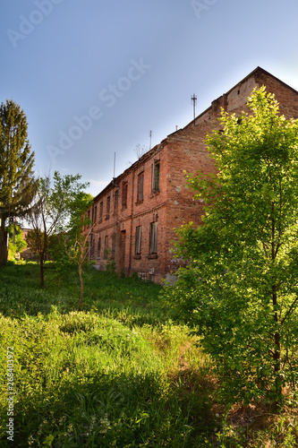 Stary, opuszczony i zrujnowany dom o zachodzie słońca.