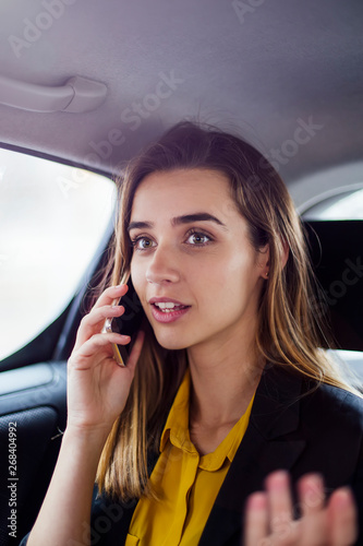 Young businesswoman talking on mobile phone in car © BGStock72