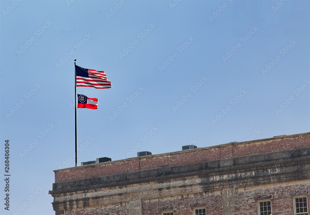 American and Georgia Flag flying over an old brick building