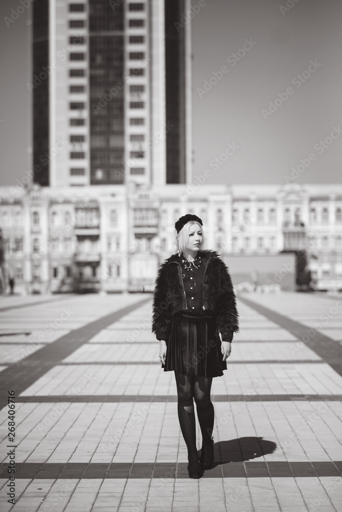 Beautiful girl in black shorts and black shirt look left and walking at the street Beautiful girl in black shorts and black shirt look left and walking at the street