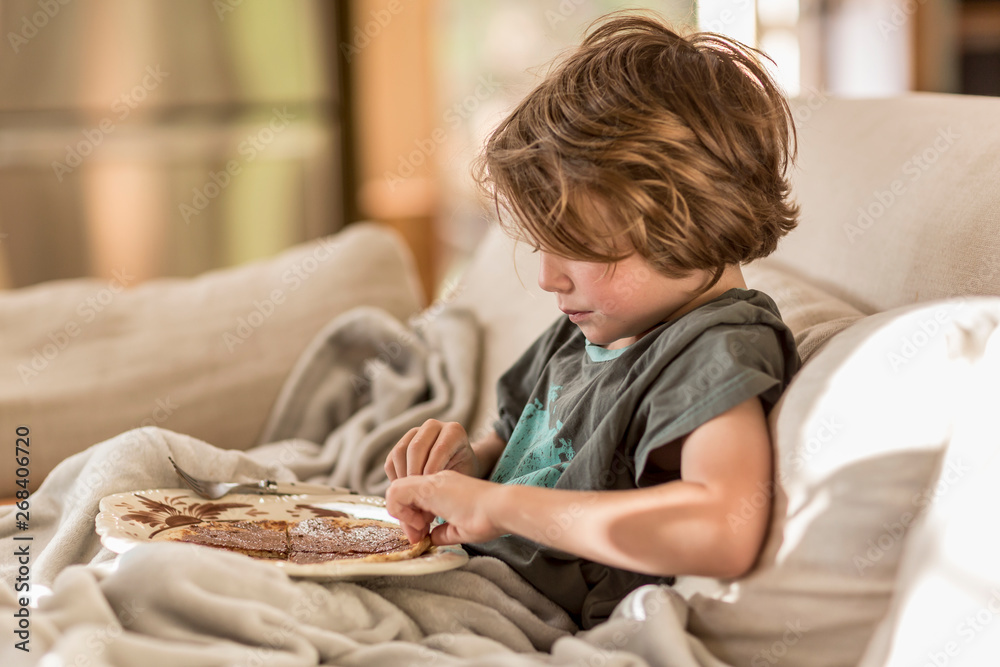 5 year old boy eating a pancake breakfast at home