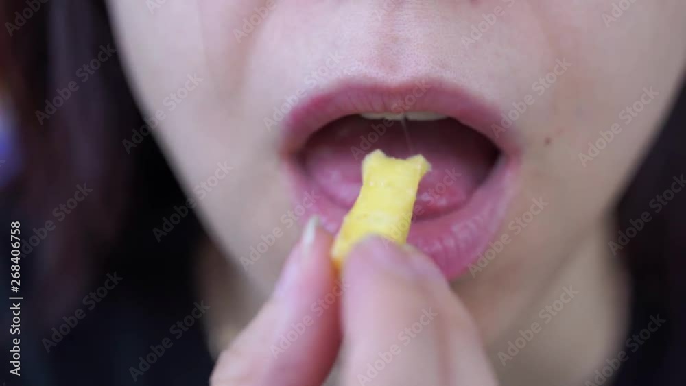Woman eating French fries, harmful and tasty fast food, close up Woman eating French fries, harmful and tasty fast food, close up