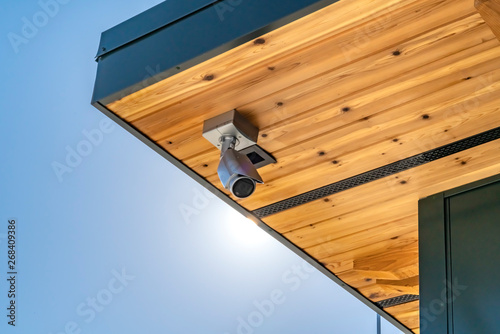 Home with security camera installed on the wooden underside of its roof