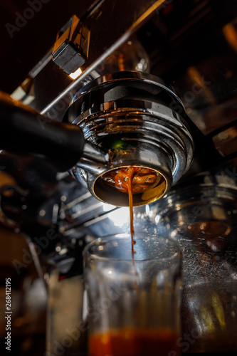 Creamy espresso coffee pouring from the coffee machine