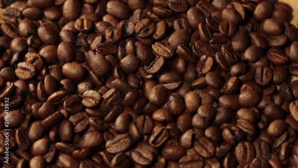 Beans factory mixing, close up. Roasted coffee bean. Beans of Coffee Raining at Slow Motion. Morning black coffee texture. Macro shot of coffee beans rotating along its axis. Beans factory mixing, close up. Roasted coffee bean. Beans of Coffee Raining at Slow Motion. Morning black coffee texture. Macro shot of coffee beans rotating along its axis.