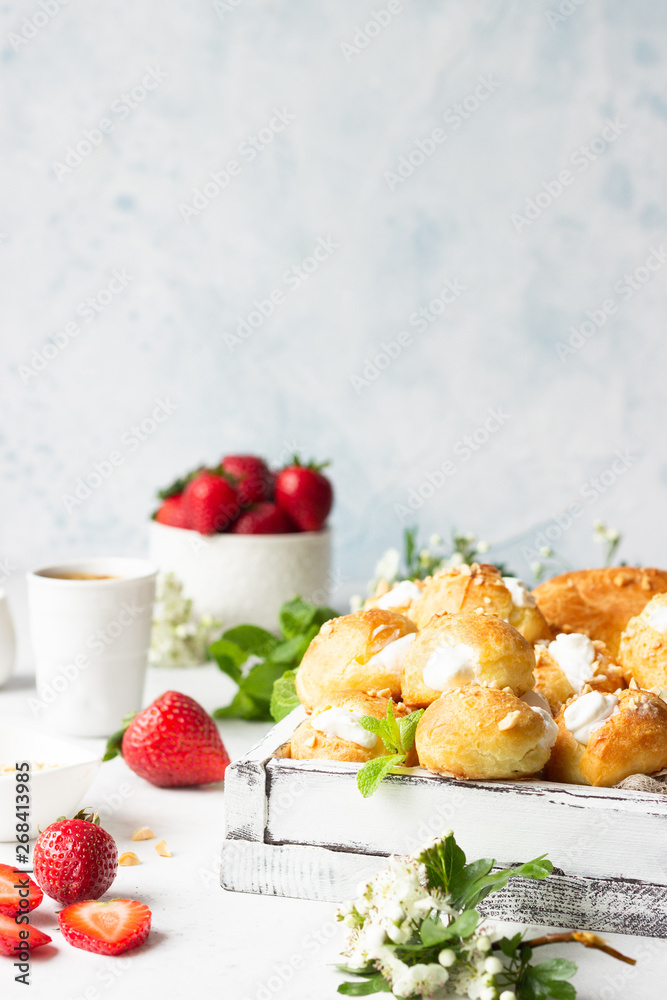 Profiteroles (choux à la crème) - French choux pastry balls filled with cottage cheese and cream with fresh strawberry, mint and cup of coffee.