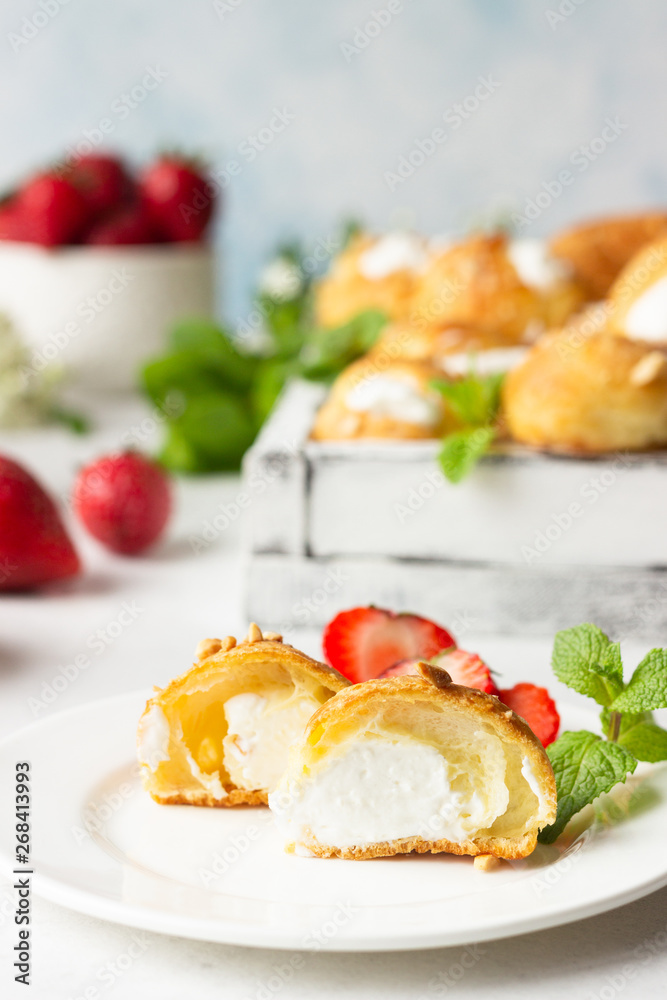 Profiteroles (choux à la crème) - French choux pastry balls filled with cottage cheese and cream with fresh strawberry, mint and cup of coffee. Profiteroles (choux à la crème) - French choux pastry balls filled with cottage cheese and cream with fresh strawberry, mint and cup of coffee.