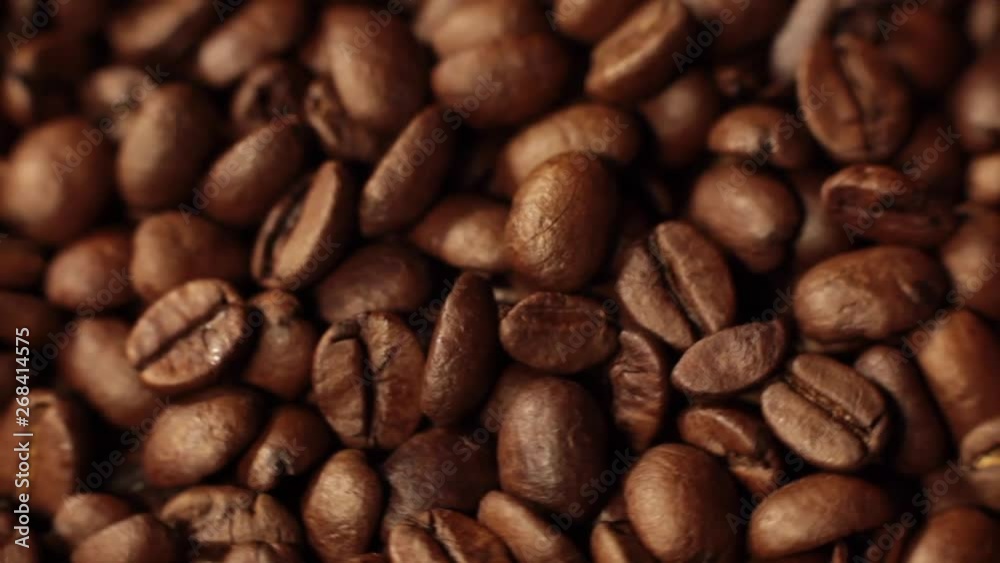 Beans factory mixing, close up. Roasted coffee bean. Beans of Coffee Raining at Slow Motion. Morning black coffee texture. Macro shot of coffee beans rotating along its axis. Beans factory mixing, close up. Roasted coffee bean. Beans of Coffee Raining at Slow Motion. Morning black coffee texture. Macro shot of coffee beans rotating along its axis.