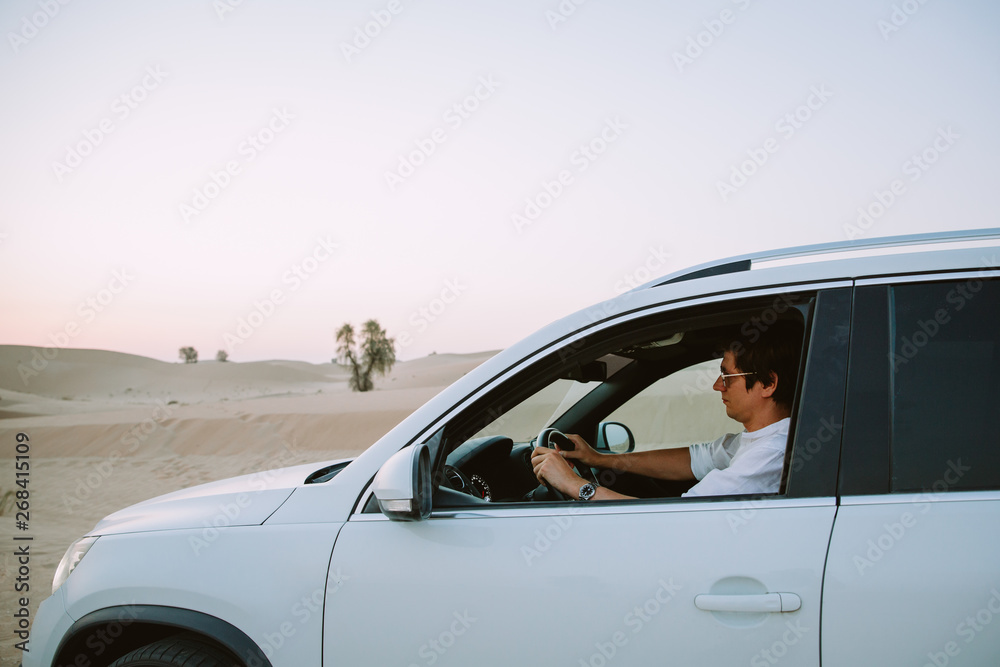 young manin the car in the desert in Dubai young manin the car in the desert in Dubai