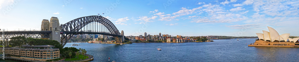 Fototapeta premium Panoramiczny widok na most portowy i North Sydney, łodzie pływające w zatoce i na rzece Parramatta. Wieczorne światło