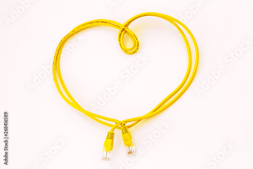 Yellow network cable folded in the shape of a heart isolated on white. Safer Internet Day. World Telecommunication and Information Society Day.