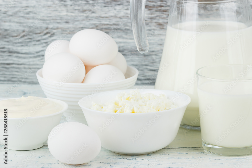 Different dairy products on the white wooden boards