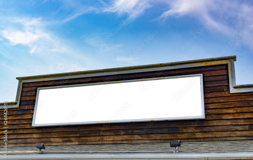 Large white blank board on a wooden facade with sky. Template, mockup, advertising use. Large white blank board on a wooden facade with sky. Template, mockup, advertising use.