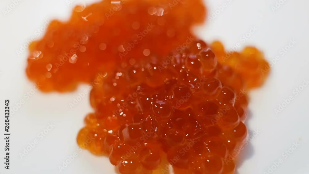 Red caviar falls down. Expensive treat close-up, real time, natural light, high angle Red caviar falls down. Expensive treat close-up, real time, natural light, high angle