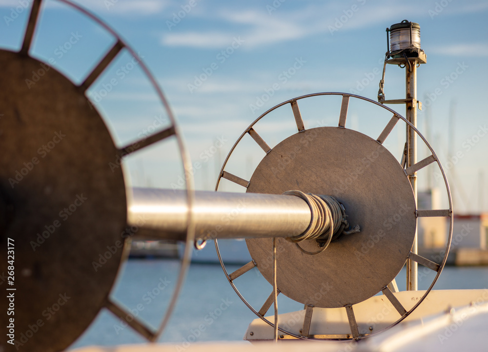 A big role for the nearby fishing net photographed on a fishing boat. In the background you can see a white fish trawler with nice bokeh.