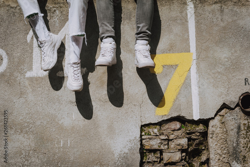 Close up of two pair of girls legs on parapet photo