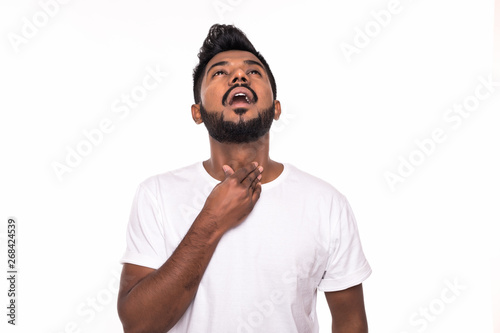 Portrait of young Indian man sore throat, hand on neck clearing throat on white background photo