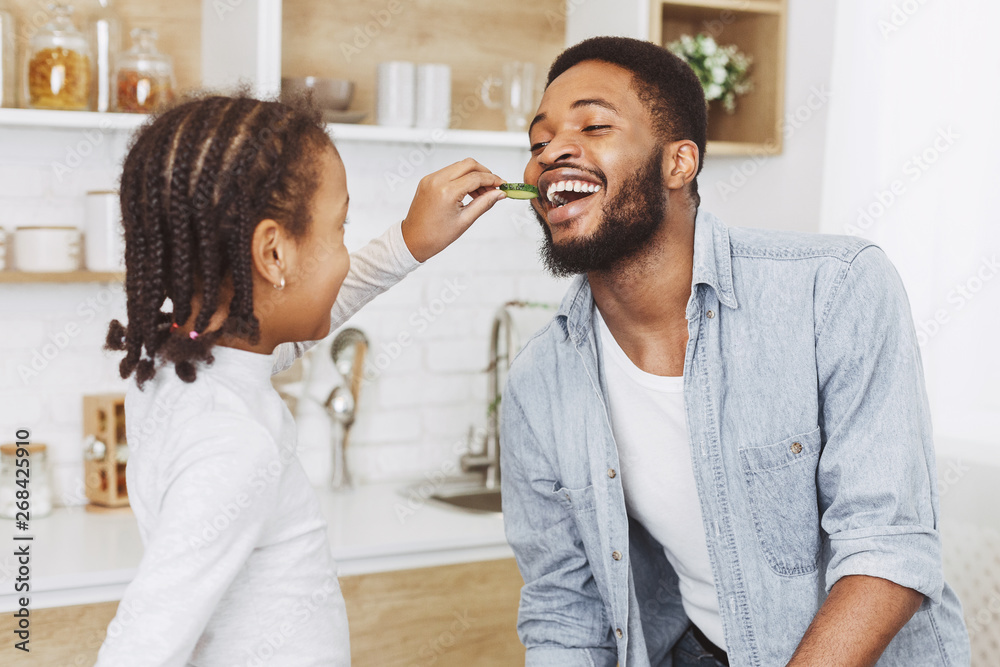 Young daughter is feeding her father with chocolate cookies Young daughter is feeding her father with chocolate cookies