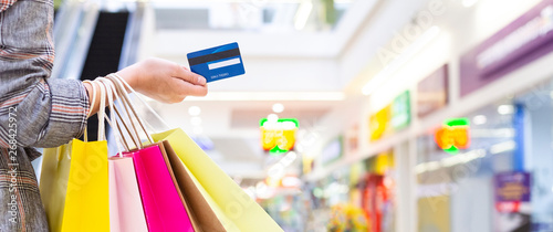 Woman Holding Credit Card And Carrying Paper Bags