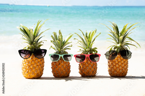 Family Of Pineapples With Sunglasses On Beach