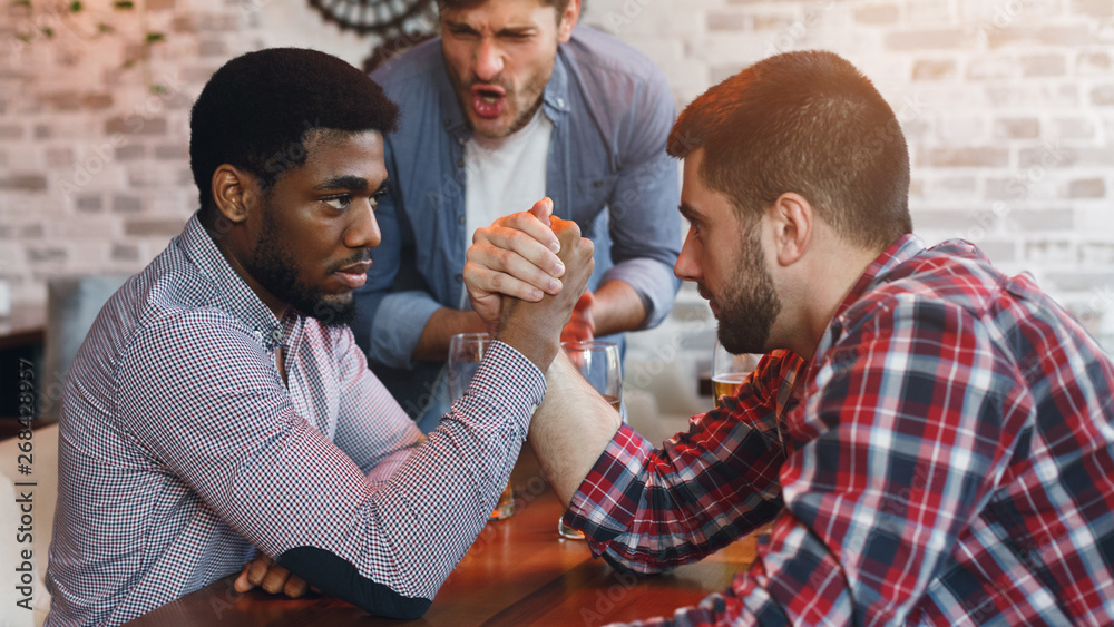 Arm Wrestling. Male Friends Having Fun In Bar Arm Wrestling. Male Friends Having Fun In Bar