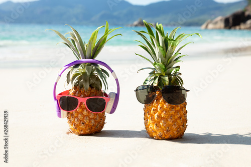 Pineapple With Headphone And Sunglasses On Sand At Beach