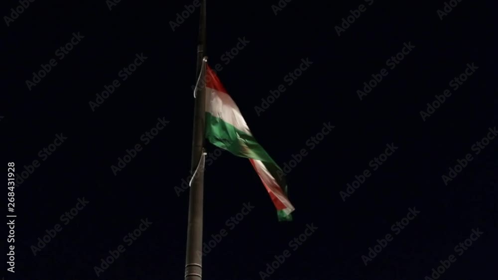 Hungarian flag flowing in wind at night viewing from below low angle Hungarian flag flowing in wind at night viewing from below low angle