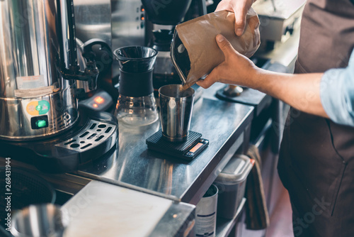 Hands of barista sifting coffee from the package