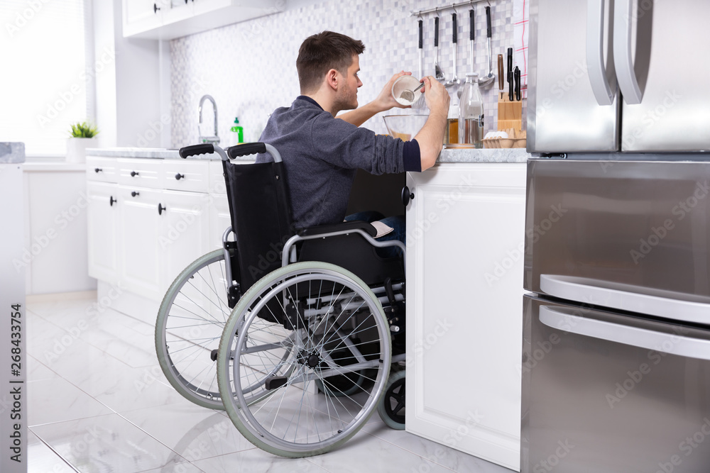 Disabled Man Preparing Food In Kitchen - obrazy, fototapety, plakaty 