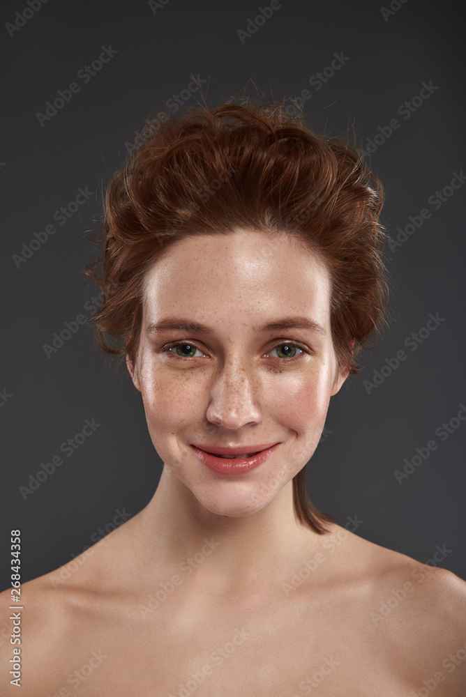Beautiful red-haired girl standing against gray background Beautiful red-haired girl standing against gray background