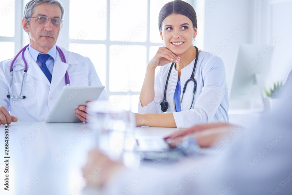 Doctors consulting with each other in a hospital conference room Doctors consulting with each other in a hospital conference room