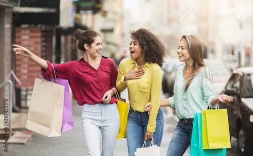 Konstfotografi Young women walking with shopping bags on street