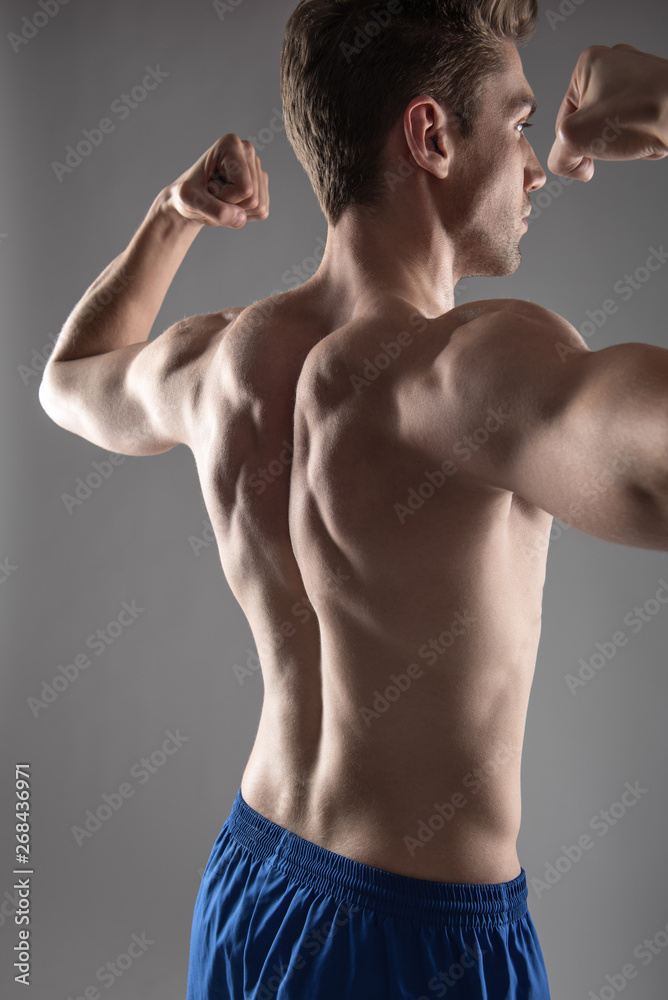 Fototapeta premium Handsome young man demonstrating his muscular body