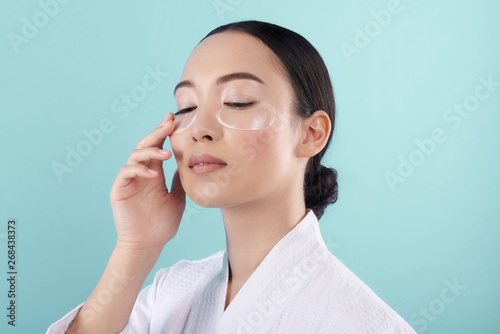 Fotografia Close up of pretty Asian lady with patches under eyes in studio